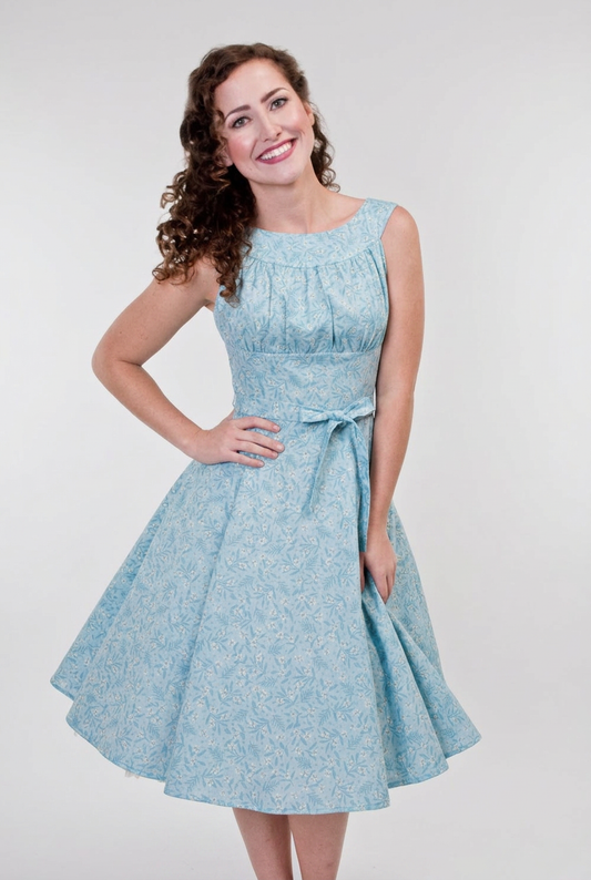 Woman wearing a light blue dress with a white background