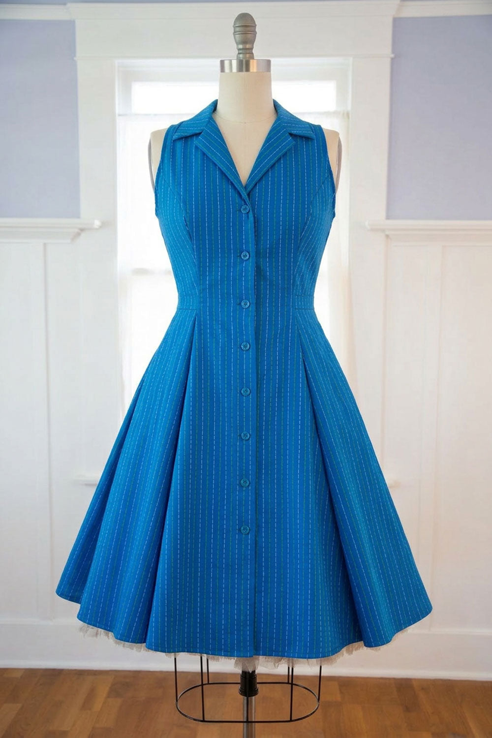Blue dress on a mannequin against a white wall