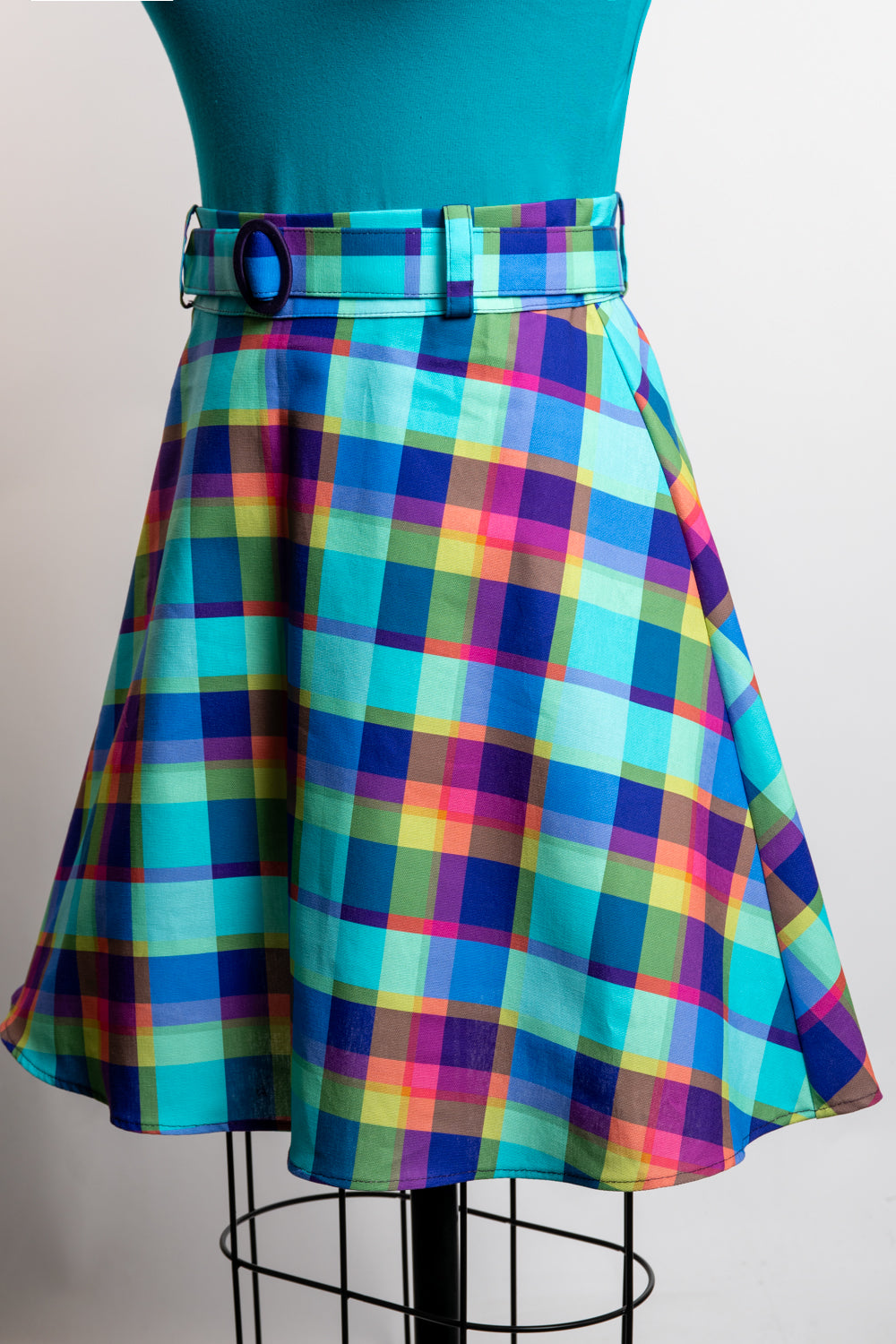 Colorful plaid skirt on a mannequin against a plain background