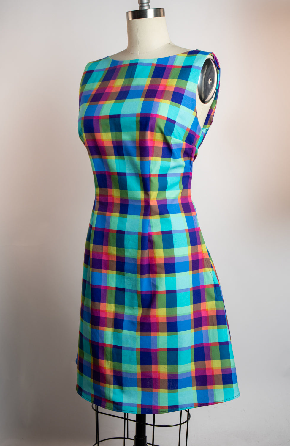 Colorful plaid dress on a mannequin against a plain background