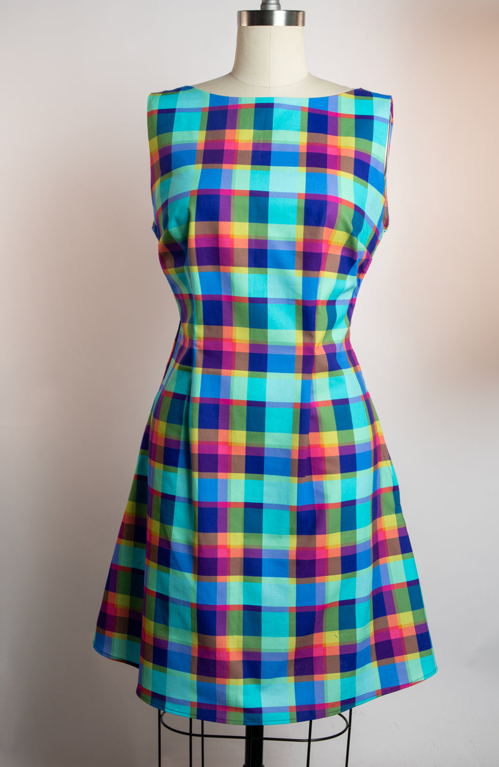 Colorful plaid dress on a mannequin against a plain background